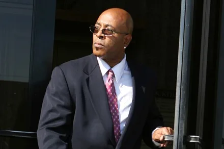 Ron Harris standing outside a home at sunset.